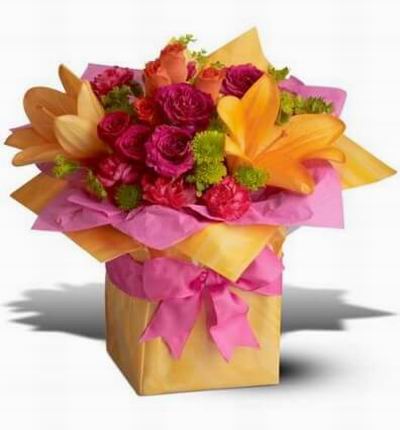Hot pink orange and chartreuse blooms nestled in tissue paper and all wrapped up in sizzling orange with a hot pink ribbon.