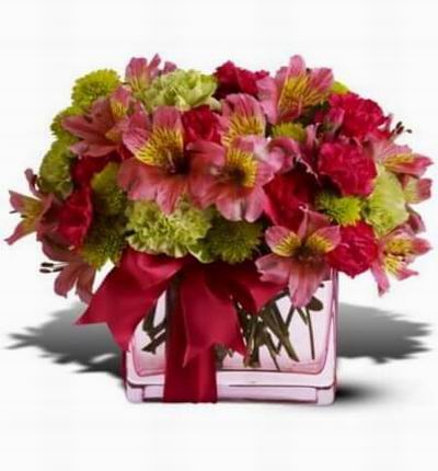 Shades of hot pink and chartreuse in a pink glass vase thats all tied up with a pink satin ribbon.
