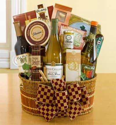 A bottle or red wine, white wine and olive oil with crackers, smoked almonds, chocolates, cheese and a sausage stick. Wine based on local wine selection. Brands will vary.  (Photo image is only an example)