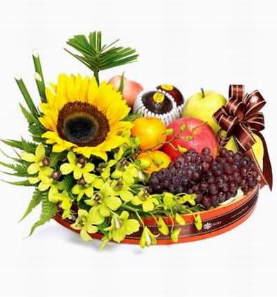 Flower tray with 1 Sunflower and orchid fillers, 2 Tangerine Oranges, 2 red Apple, 2 green Apples, 2 plums and two bunch of Globe Grapes. A basket will be used if the tray is not available.