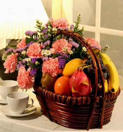 Flower basket of 8 pink Carnations, Stock and fillers with 1 Dragon Fruit, 1 Mango, 1 Kiwi, 1 Tomato, 3 Bananas and Grapes.