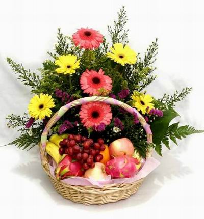 Flower basket of 3 pink and 4 yellow Gerebera Dasies, stock and Greenery fillers with 2 Dragon Fruits, 2 red Apples, 1 Orange, 3 Bananas and Grapes.