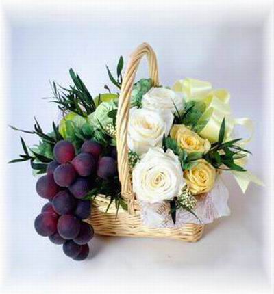Fruit flower basket with 5 white Roses, 5 yellow Roses with Globe Grapes and Greenery fillers.