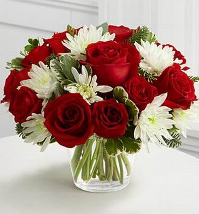 12 Rich red roses with  6 white chrysanthemums, assorted Christmas greens and eucalyptus.