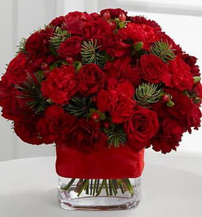 15 Bright red spray roses, 10 red mini carnations, red hypericum berries and assorted holiday greens.