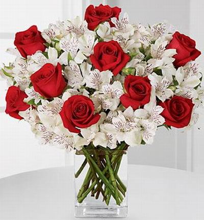 9 red roses, snowy white Peruvian lilies accented with Israeli ruscus greens.
