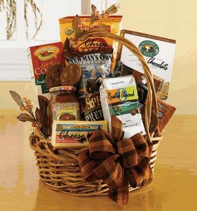 A basket of Chocolate Cookies, Pretzels, Roasted Almond Cookies, Soft Cookies, Chips and Salsa and a block of Cheese.