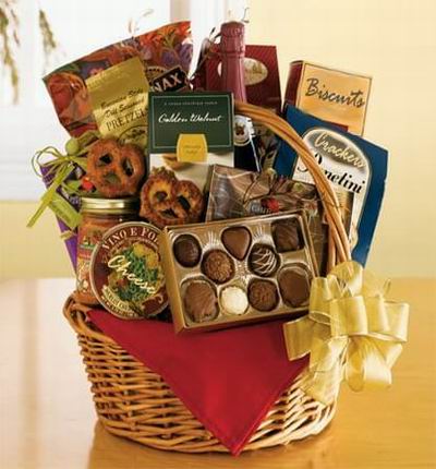 A basket of Assorted Chocolates, Pretzels, Cheese, Crackers, Salsa Sause, Golden Walnuts, Biscuits and a bottle of Red Wine.