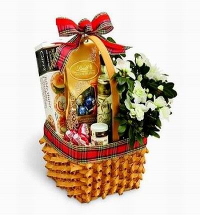 A basket of Cracker Wafers, Chocolate candys, Jam, Olives with flowers.
