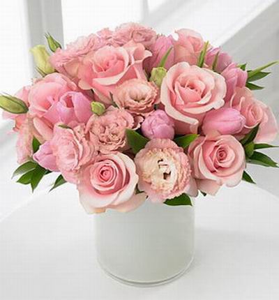 A pink mix of 8 roses, 6 carnations and 8 tulips and green leafs