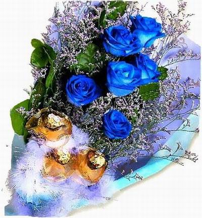 6 blue Roses with 3 chocolate balls at the base with greenery.