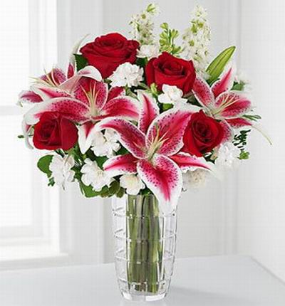 4 red Roses, 4 pink Lilies and white blossom fillers.