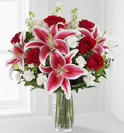 6 red Roses, 4 pink Lilies and white blossom fillers.