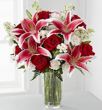 7 red Roses, 4 pink Lilies and white blossom fillers.