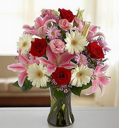 4 red Roses, 5 pink Lilies, 4 Gerbera Daisies, Eustomas and Shasta Daisy filers.