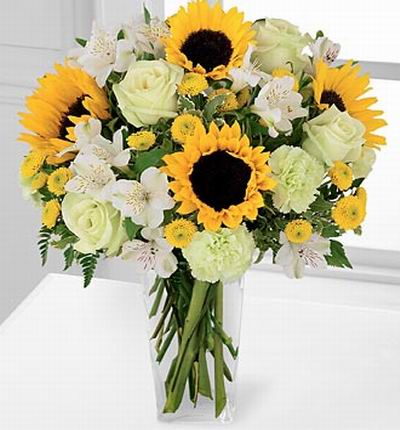 4 Sunflowers, 4 white Roses, 3 white pistachio Carnations, 9 Alstomerias and yellow button poms.