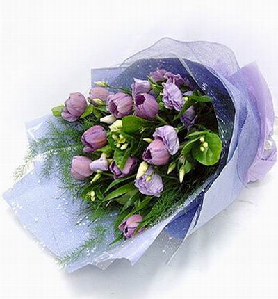 Hand tied bouquet of 9 purple tulips and 6 Eustomas and greenery.