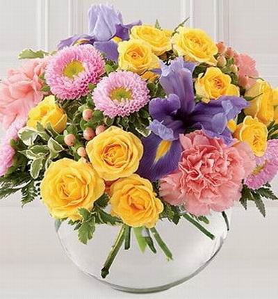 12 yellow Roses, 3 pink Carnations, 2 Iris, pink ball poms and fillers.