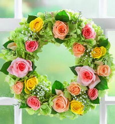 16 multi color Rose mix with Baby Breath arranged in a wreath. Artificial and plastic materials are used.
