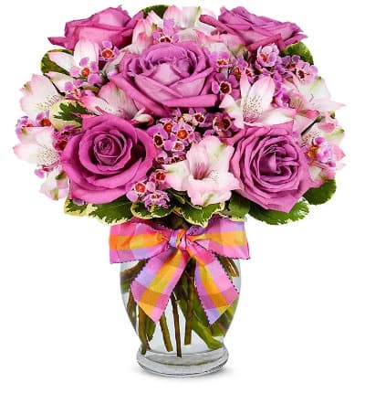 * Purple Roses
* Pink Alstroemeria
* Purple Waxflower
* Clear Fluted Vase
* Decorative Ribbon