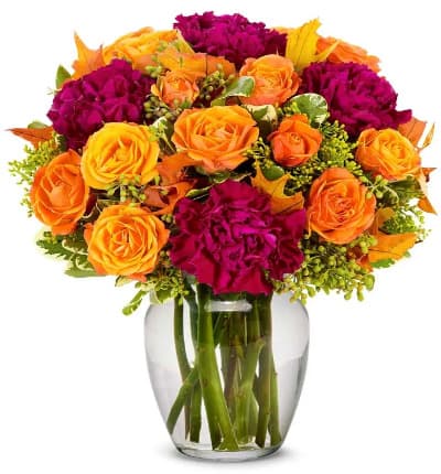 * Orange Spray Roses
* Magenta Carnations
* Solidago
* Clear Glass Vase