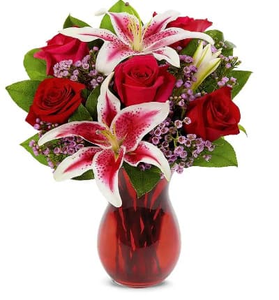 * Red Roses
* Stargazer Lilies
* Waxflower
* Seasonal Greens
* Red Swirl Vase
