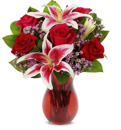 * Red Roses
* Stargazer Lilies
* Waxflower
* Seasonal Greens
* Red Swirl Vase