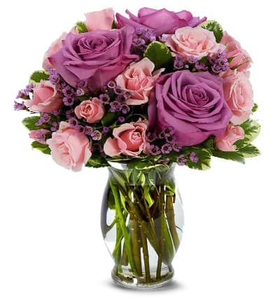 * Purple Roses
* Pink Spray Roses
* Pink Waxflowers
* Seasonal Greens
* Glass Vase
