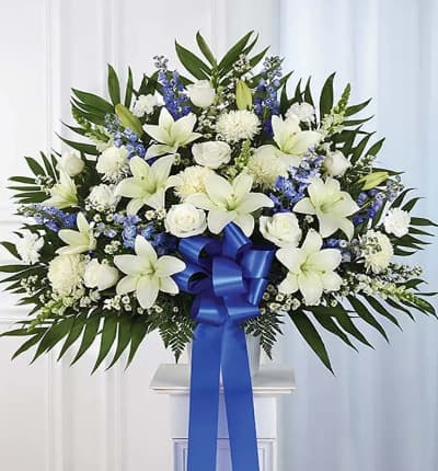 The Blue & White Sympathy Standing Basket will thoughtfully convey your condolences with an elegant selection of hand picked blooms from our preferred local florist. Roses, Lilies, Snapdragons and many other exquisite choices are expertly woven together in a classic funeral mache container. The arrangement measures approximately 32