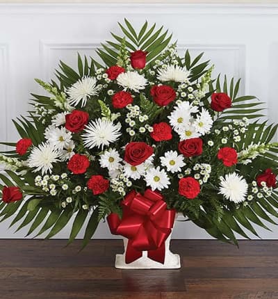 The red and white sympathy floor basket with fresh blooms including red and white flowers. Classic red roses and carnations along with white gladioli and spider mums are a wonderful sympathy gift for the funeral of a dear friend or loved one. Medium arrangement (shown) measures approximately 30