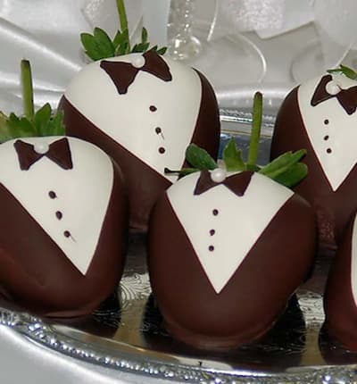These classically decorated strawberries make the perfect wedding or anniversary gift! The lovely groom, or grooms, will be amazed by this thoughtful, elegant, and delicious gift. Twelve Belgian white and dark chocolate covered strawberries are hand decorated with a chocolate tuxedo and bow-tie, then packed in a tasteful gift box and shipped next day to your lucky recipient. Please note: Since these are crafted by our artisans, no two will look exactly the same.
Includes:
* 12 Bride Themed Strawberries
* White Chocolate Dipped and Decorated
* Gift Box
* Complimentary Card Message.
ALLERGEN ALERT: Product contains egg, milk, soy, wheat, peanuts, tree nuts and coconut. We recommend that those with food related allergies take the necessary precautions.
