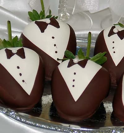 These classically decorated strawberries make the perfect wedding or anniversary gift! The lovely groom, or grooms, will be amazed by this thoughtful, elegant, and delicious gift. Twelve Belgian white and dark chocolate covered strawberries are hand decorated with a chocolate tuxedo and bow-tie, then packed in a tasteful gift box and shipped next day to your lucky recipient. Please note: Since these are crafted by our artisans, no two will look exactly the same.
Includes:
* 12 Bride Themed Strawberries
* White Chocolate Dipped and Decorated
* Gift Box
* Complimentary Card Message.
ALLERGEN ALERT: Product contains egg, milk, soy, wheat, peanuts, tree nuts and coconut. We recommend that those with food related allergies take the necessary precautions.
