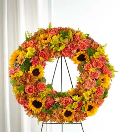 This lush fall themed wreath is a beautiful way to express yourself. The bright golden glow of sunflowers, orange roses, butterscotch daisies and other warm fall flowers, makes a beautiful visual arrangement. The spray measures approximately 26